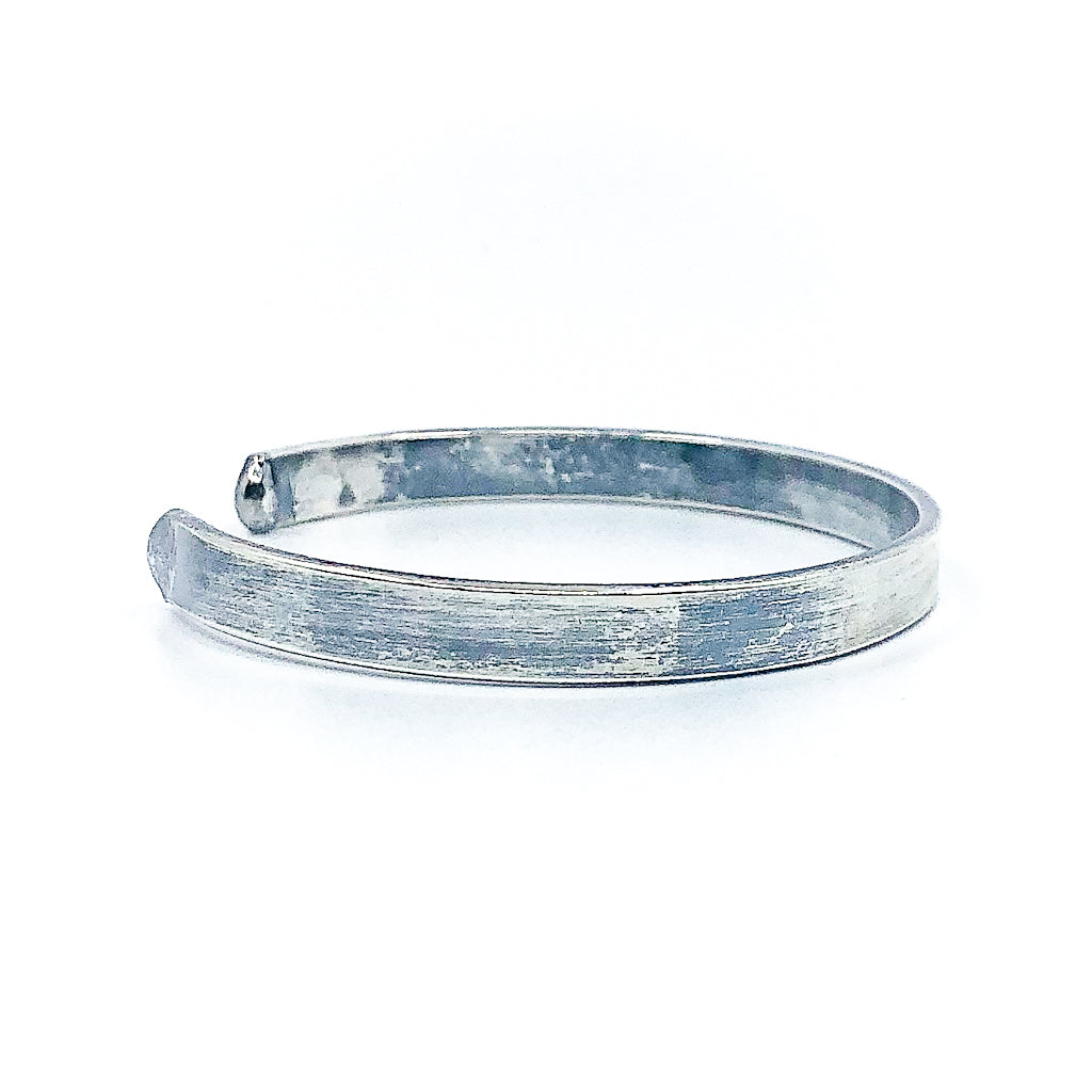right side view of Oxidized Sterling Flat Band Cuff with Paw Print by Judie Raiford