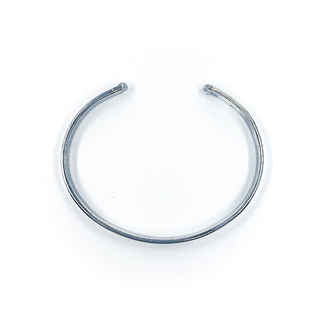 over top view of Oxidized Sterling Flat Band Cuff with Paw Print by Judie Raiford