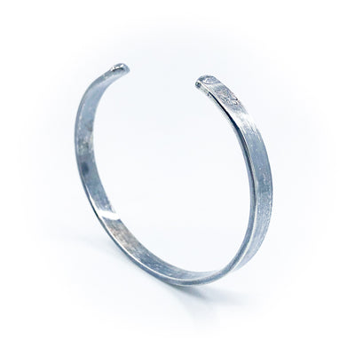 angled view of Oxidized Sterling Flat Band Cuff with Paw Print by Judie Raiford