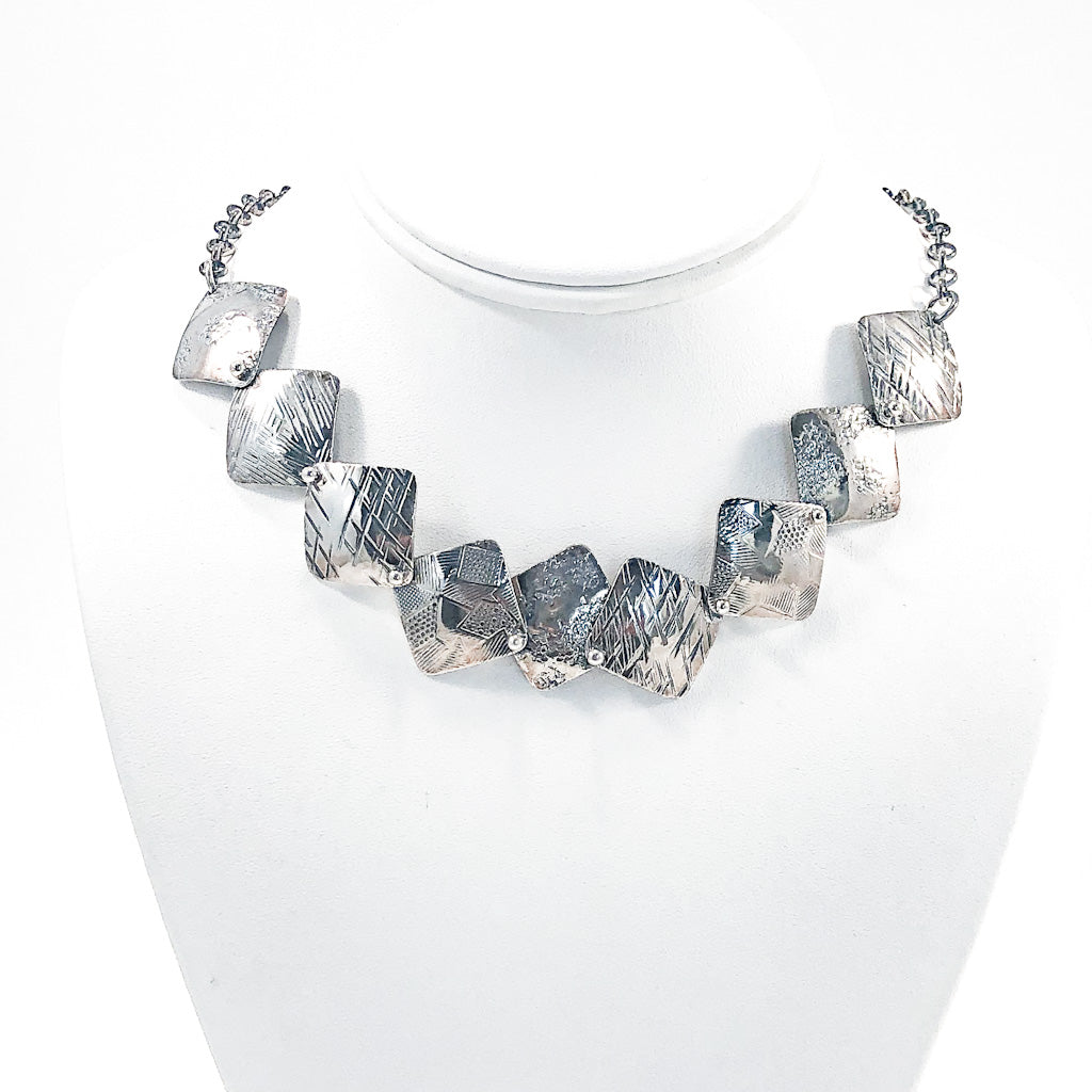 Oxidized Sterling Traveling Squares Necklace by Judie Raiford on white display mannequin