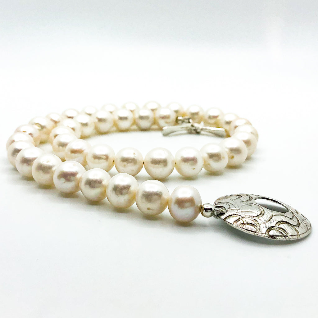 side angle view of Sterling Cupcake Necklace with White Baroque Pearls by Judie Raiford