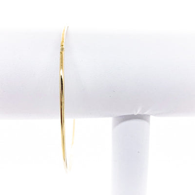 14k Gold Filled Bangle by Judie Raiford hanging on white bracelet display stand