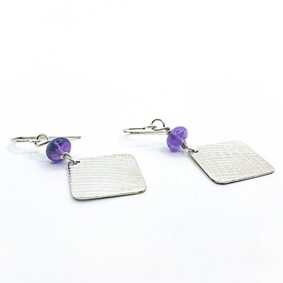 side angle view of Sterling Goat Earrings with Upside Down Amethyst by Judie Raiford