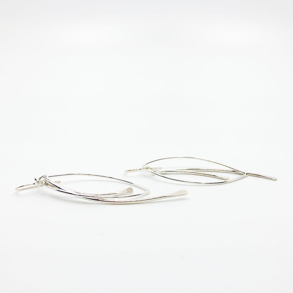 side angle view of Sterling Large Paddle Bag Earrings by Judie Raiford