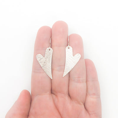 Sterling Silver Textured Heart Earrings by Judie Raiford held in hand