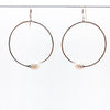 Sterling Twisted Hoop Pearl Earrings by Judie Raiford hanging on a wire