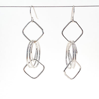 Sterling JW Earrings by Judie Raiford hanging on a wire