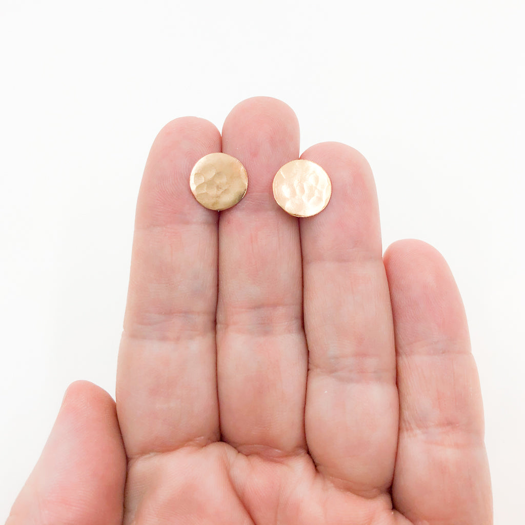 14k Gold Filled Textured Circle Stud Earrings by Judie Raiford held in hand