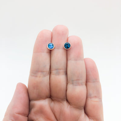 6mm Abalone Cabochon Stud Earrings by Judie Raiford held in hand