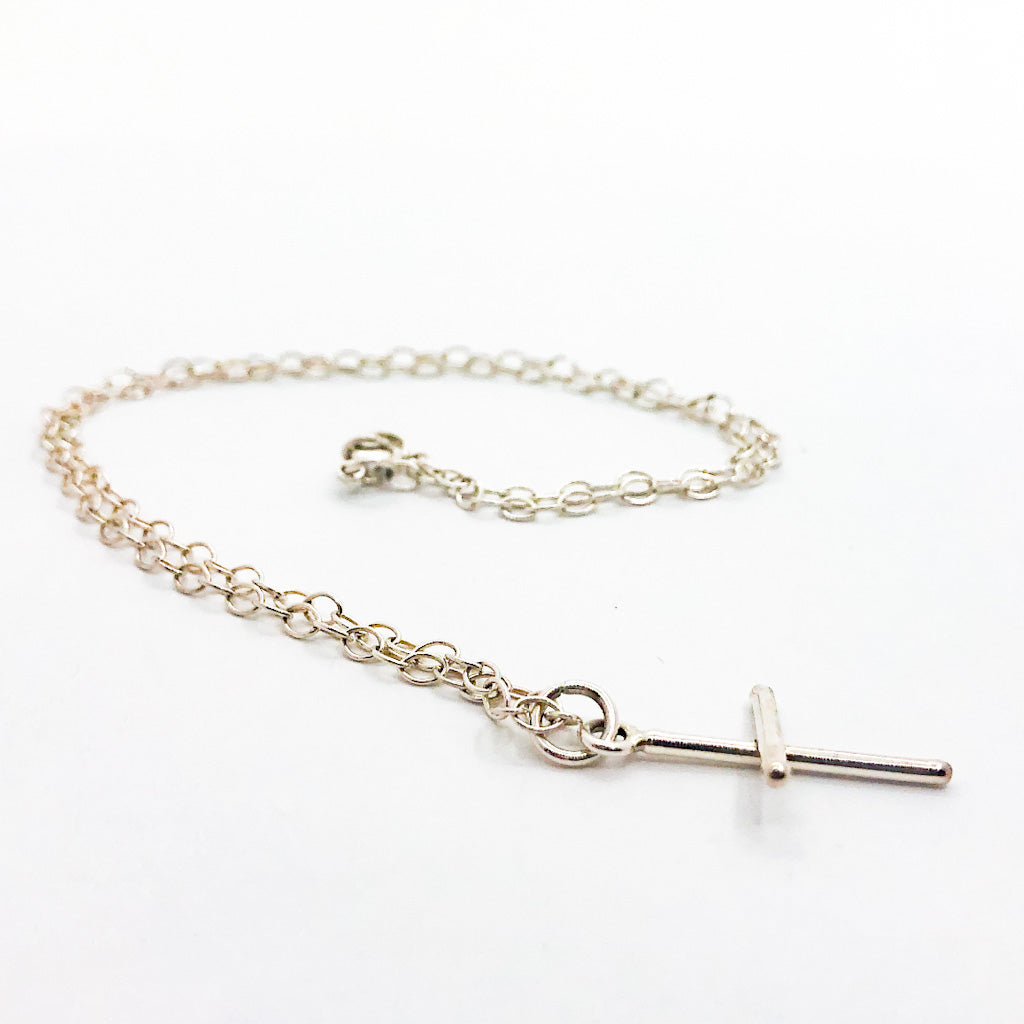 side angle view of Sterling Tiny Cross Necklace by Judie Raiford