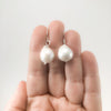 Small White Baroque Pearl Earrings by Judie Raiford held in hand