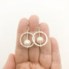 Sterling Not Naught Round Pearl Earrings with White Pearls by Judie Raiford held in hand