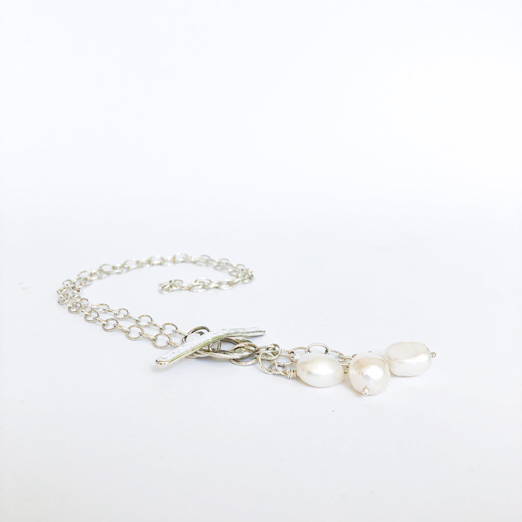 angle flat lay of Dale 3-Pearl Lariat Necklace by Judie Raiford