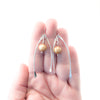 Sterling Wishbone Earrings with Champagne Pearls by Judie Raiford held in hand