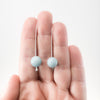 Sandblasted Peruvian Opal Earrings by Judie Raiford held in hand