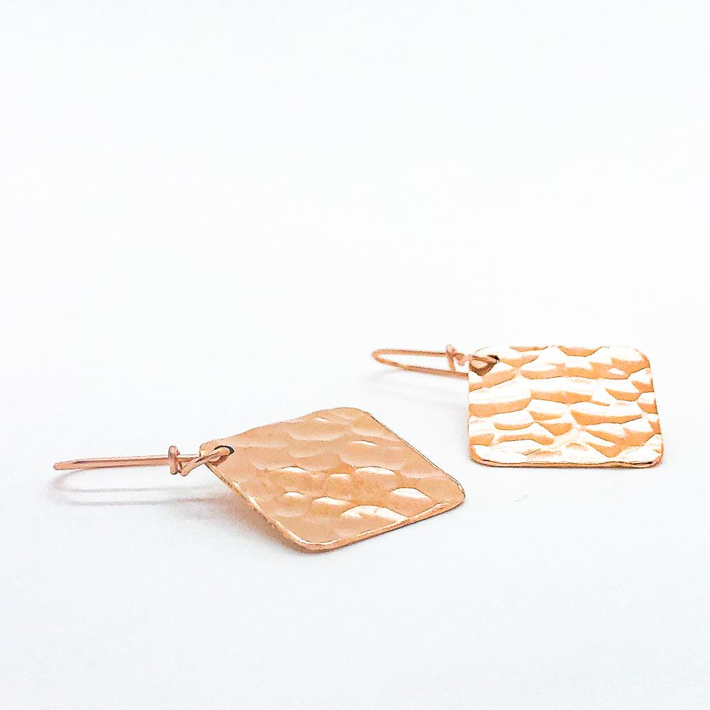 side angle flat lay 14k Rose Gold Ball Pein Square Earrings by Judie Raiford