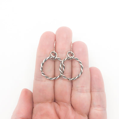 polished and oxidized sterling silver Double Twist Hoop Earrings by Judie Raiford held in hand
