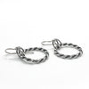 side angle view of polished and oxidized sterling silver Double Twist Hoop Earrings by Judie Raiford