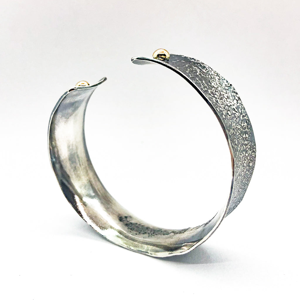side angle view of 3/4" Mom's Hammer Oxidized Sterling Anticlastic Cuff with 14k Gold Balls by Judie Raiford