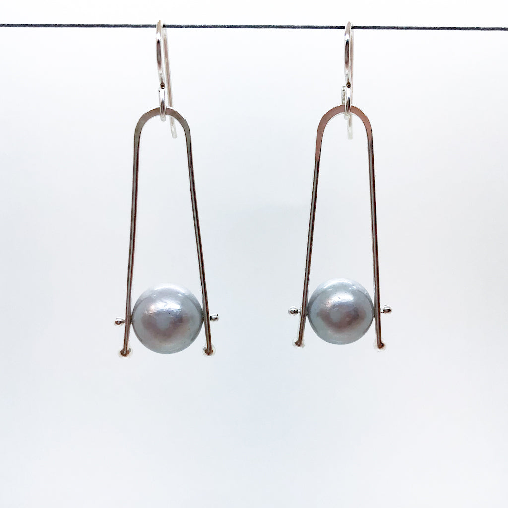 Short Tic Toc Earrings with Gray Pearls by Judie Raiford hanging on a wire