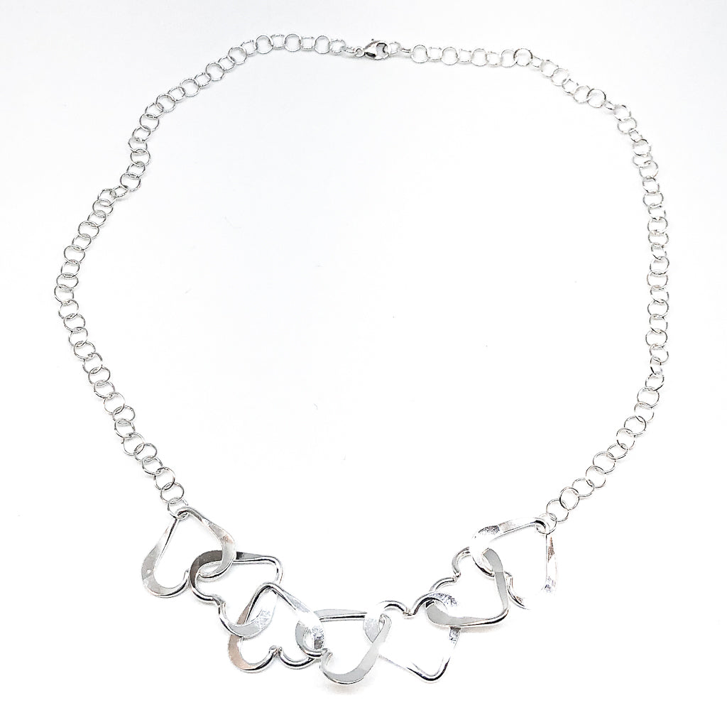 flat lay of Hammered Sterling Silver 7 Heart Necklace by Judie Raiford