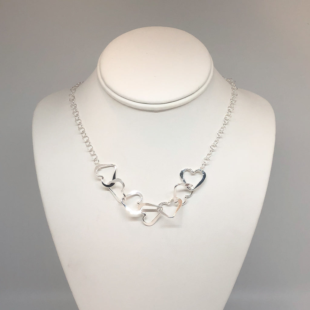 Hammered Sterling Silver 7 Heart Necklace by Judie Raiford on mannequin