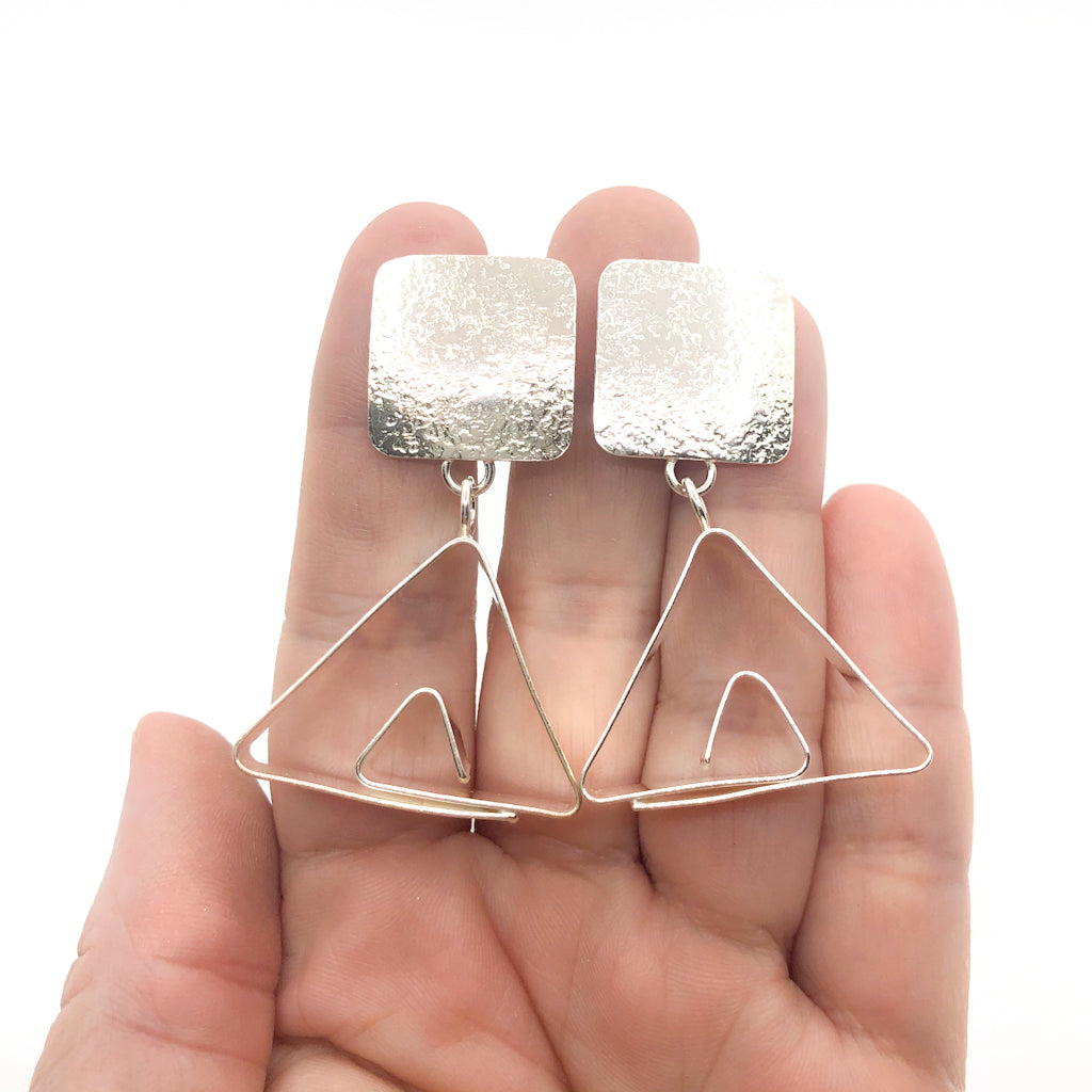 Sterling Disc Top Teepee Earrings by Judie Raiford held in hand