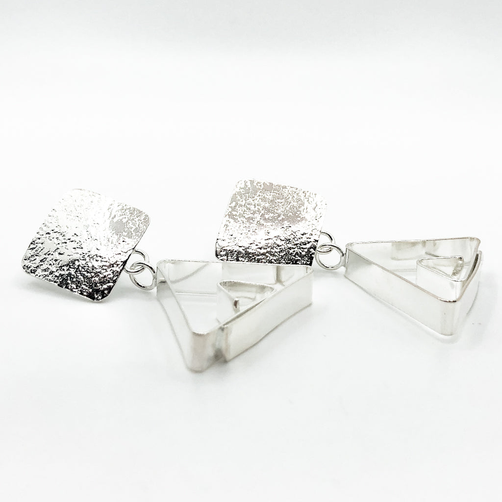 side angle view of Sterling Disc Top Teepee Earrings by Judie Raiford