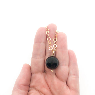 Black Onyx and 14k Gold Filled Necklace by Judie Raiford held in hand
