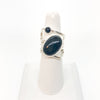 Sterling Wrap Ring with Oval Black Onyx by Judie Raiford on white finger ring display stand