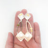 Sterling and 24k Square Tip Big White Pearl Earrings by Judie Raiford held in hand