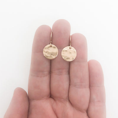 14k Gold Filled ball Pein Hammered Mini Circle Earrings by Judie Raiford held in hand