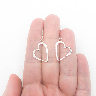 Small Sterling Silver Hammered Open Heart Earrings by Judie Raiford held in hand
