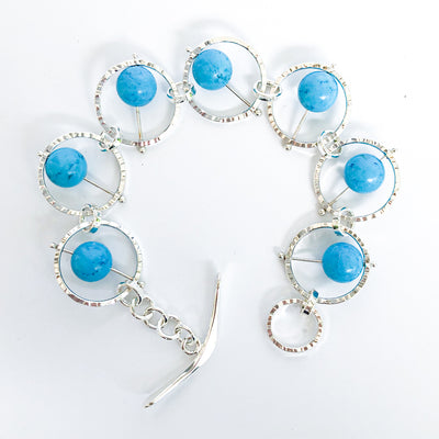 Flat Lay curl view of Not Naught Round Sterling Bracelet with Turquoise by Judie Raiford