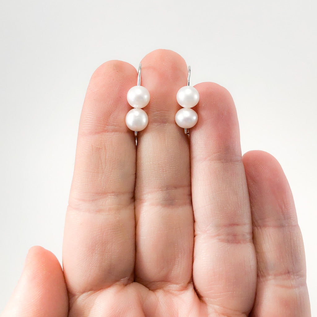 Sterling Two Pearl Earrings by Judie Raiford held in hand