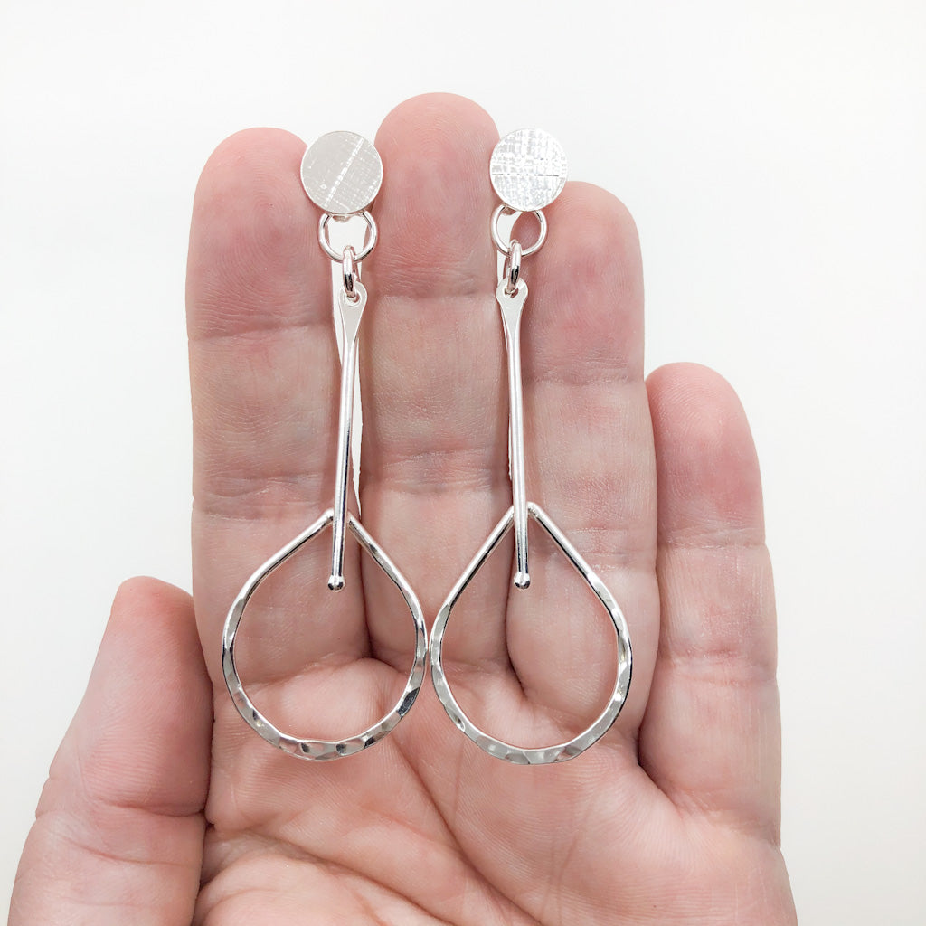 Sterling Fat Bottomed Girl Earrings with Stick by Judie Raiford held in hand