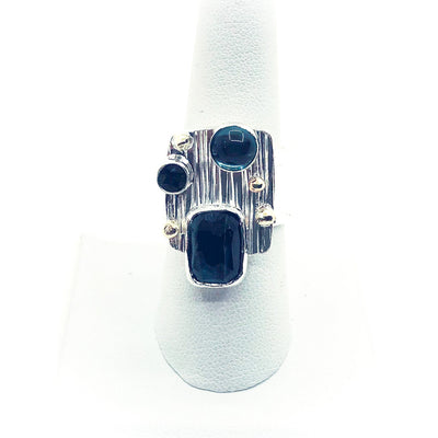size 7.5 Sterling Silver Half Platter Ring with 14k and Blue Green Tourmaline by Judie Raiford on white ring display stand