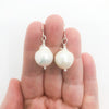 Large White Baroque Pearl Earrings by Judie Raiford held in hand
