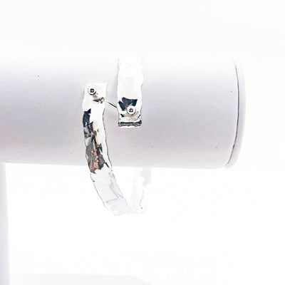 Sterling Bypass Anticlastic Bangle by Judie Raiford on white jewelry display stand