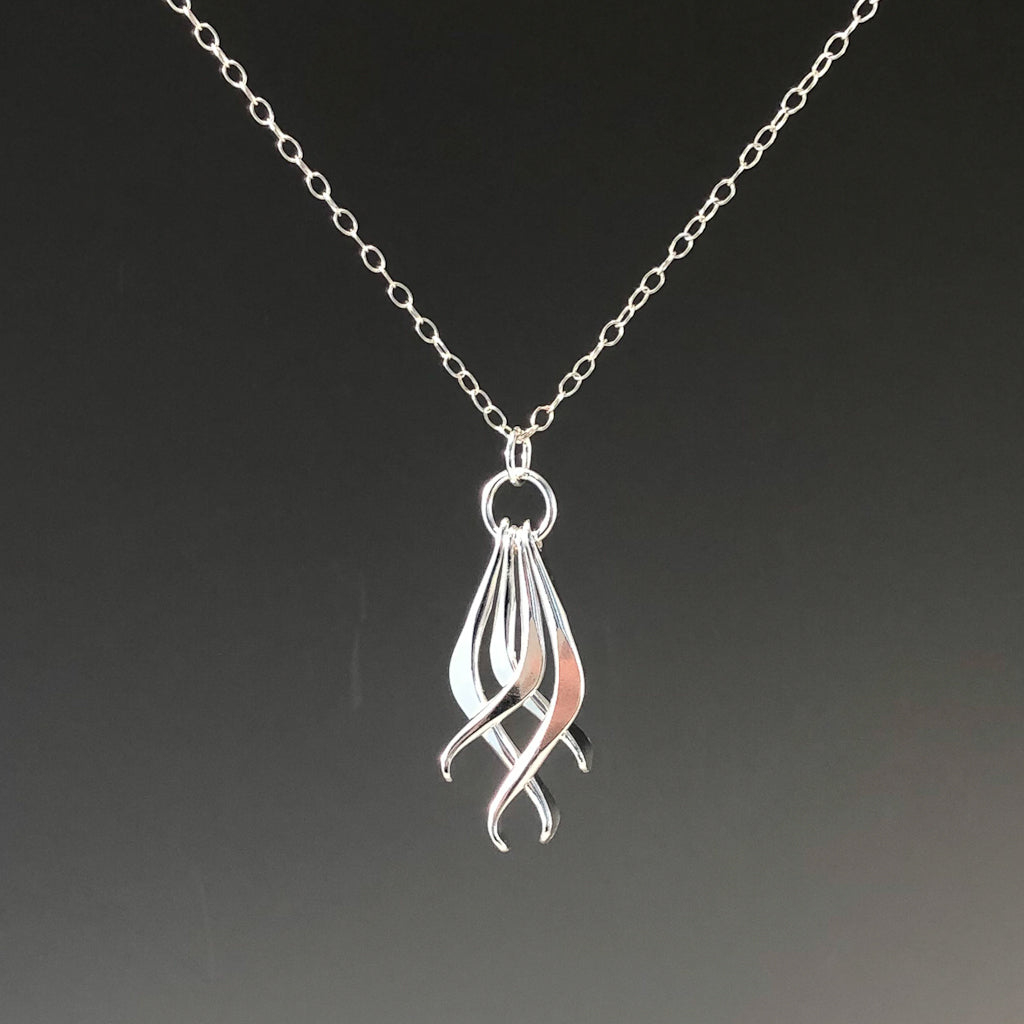 detail view of Four Dang Necklace by Judie Raiford against dark background