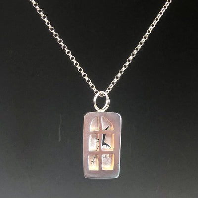 pendant hanging against black of Windows of Opportunity Necklace by Ling-Yen Jones