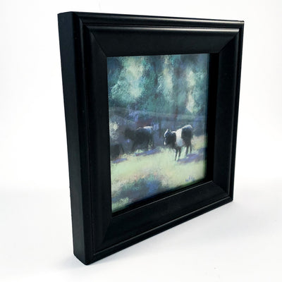 side angle view of pastel painting Black & White Cattle in black frame by Wanda Cox