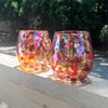 pair of Red, Gold & Silver Wine Tumblers by Nate Nardi sitting on deck hand rail with outdoor setting