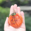 Handblown Glass Peach Ornament by Nate Nardi held in hand
