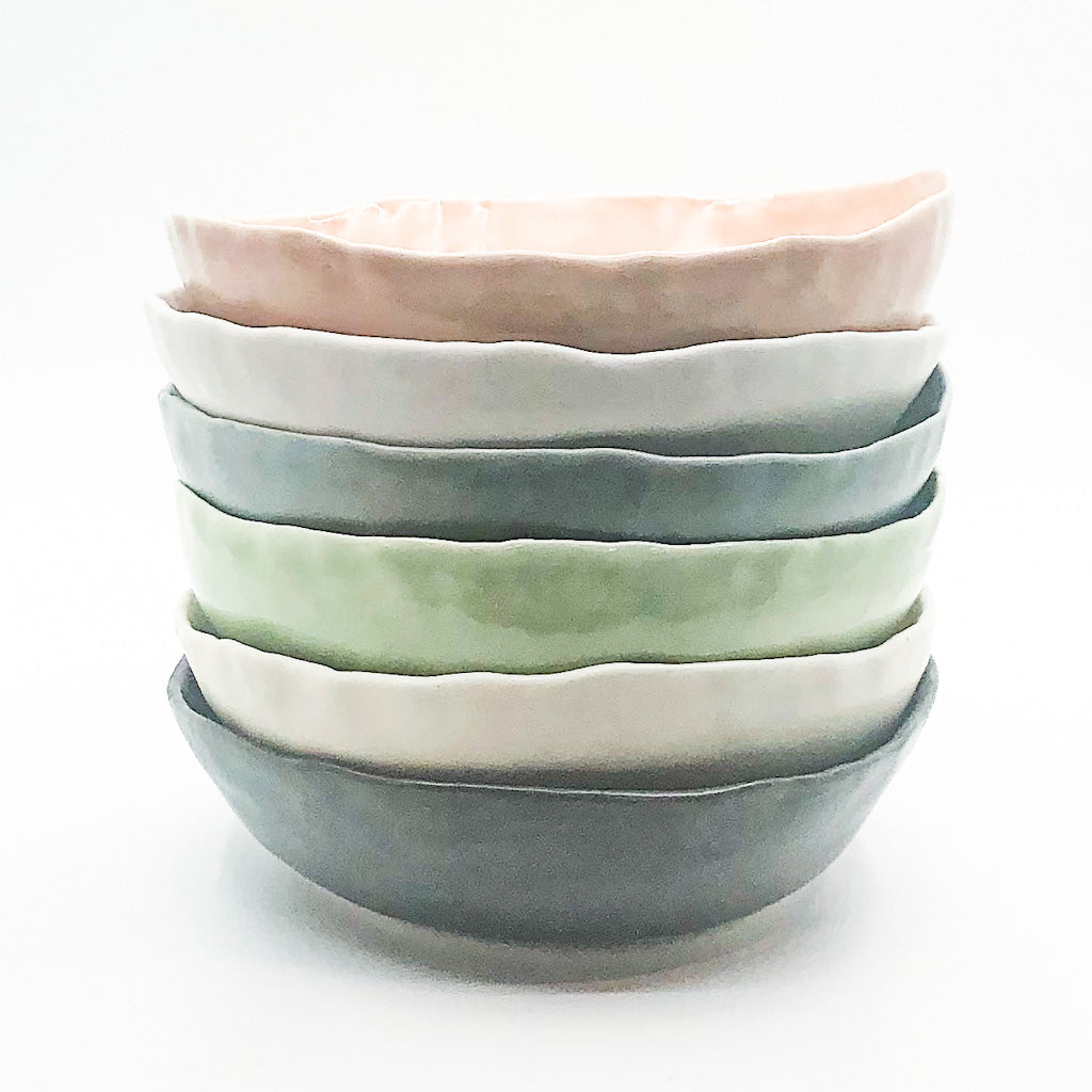 stack of multi colored small bowls by Nona Kelhofer